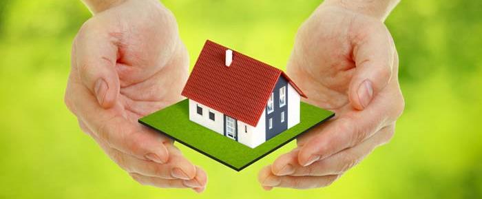 Hands covering a mini house